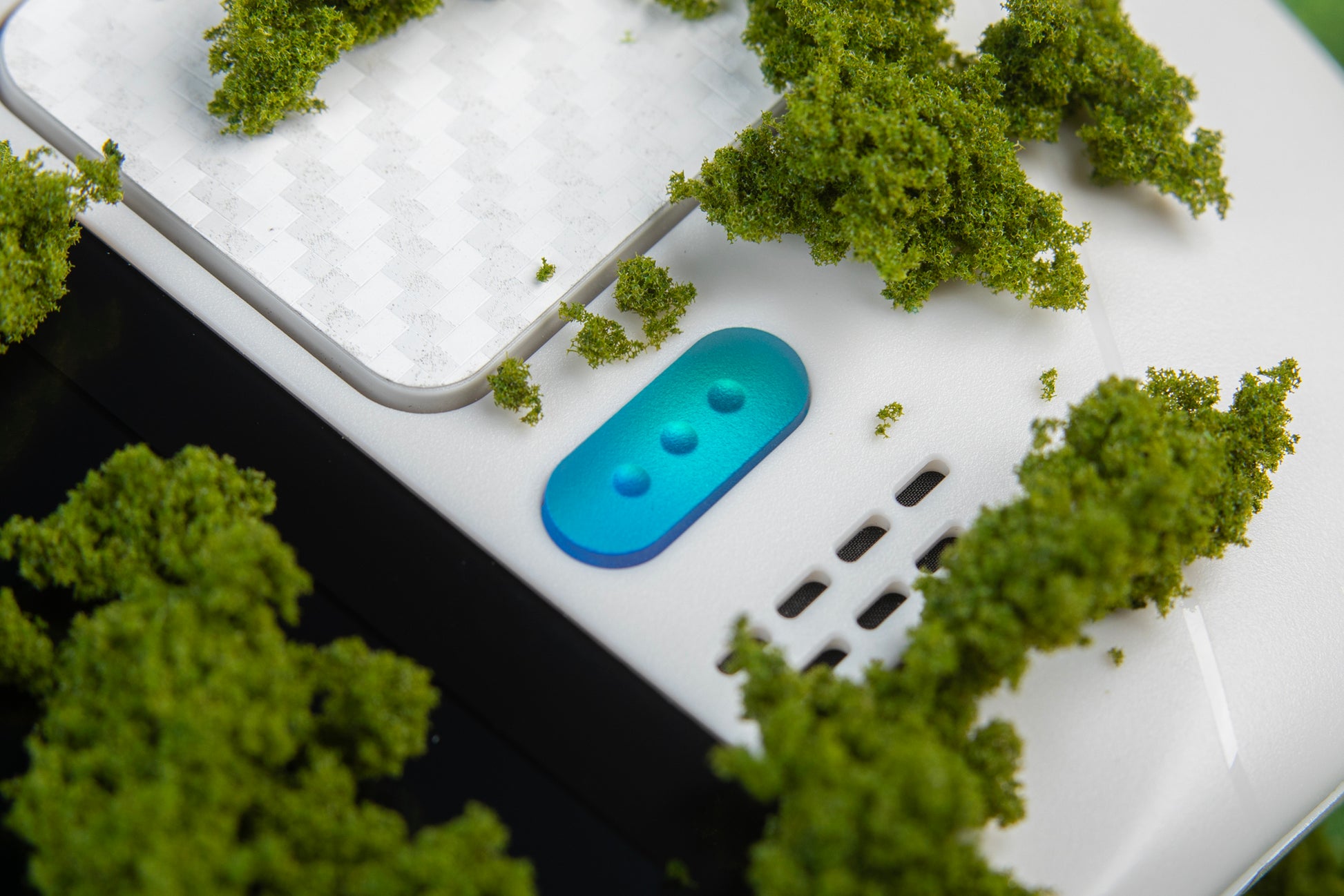 Moss growing on a white steam deck with holographic blue buttons