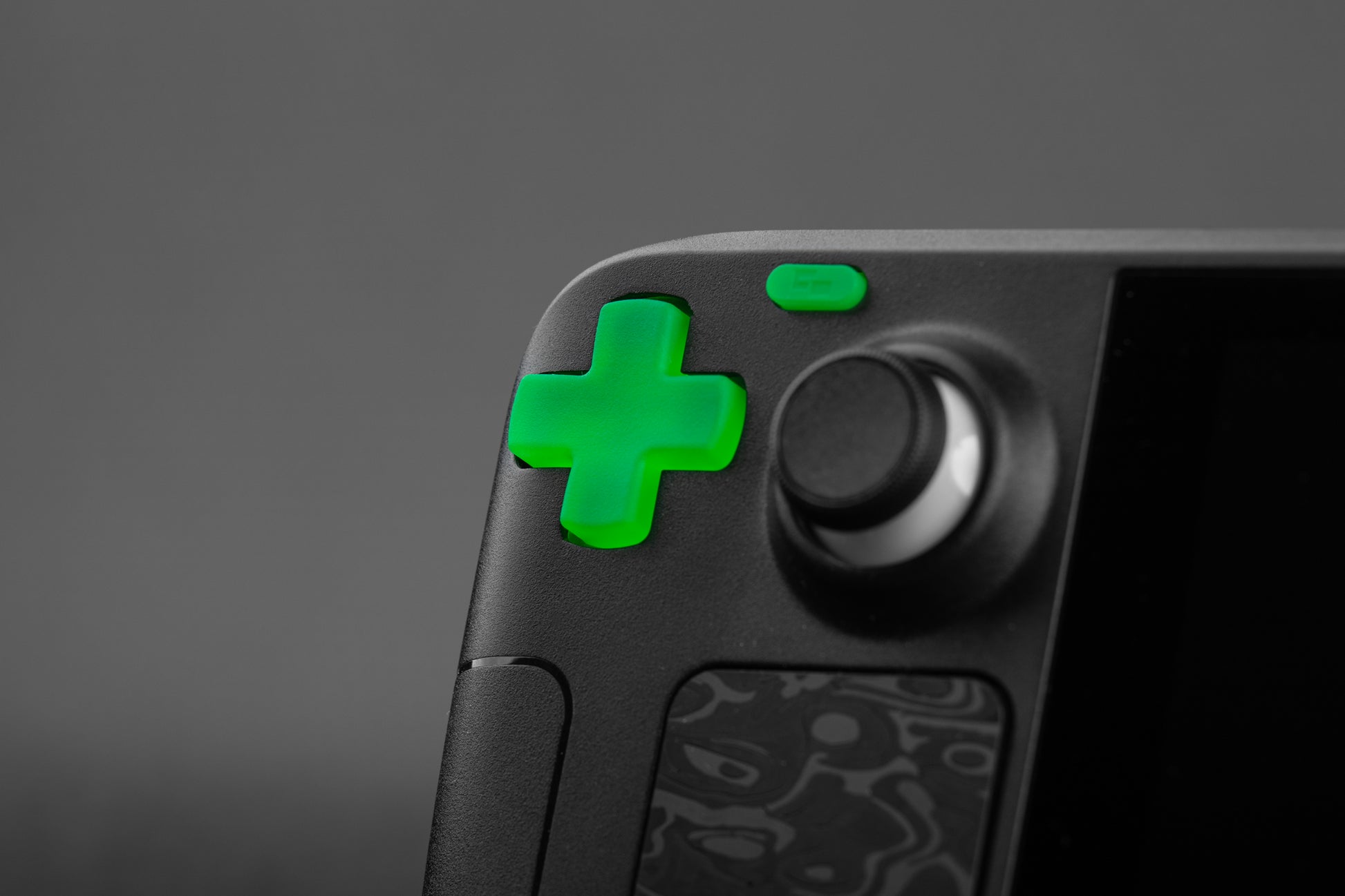 Close-up of a steam deck with lime green dpad on a dark background