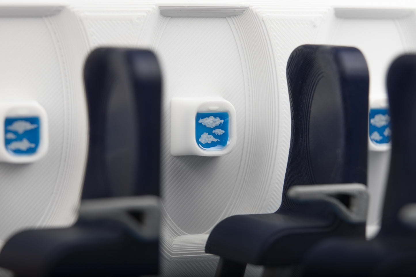 Airplane artisan keycap shows clouds, blurry airplane seats in foreground