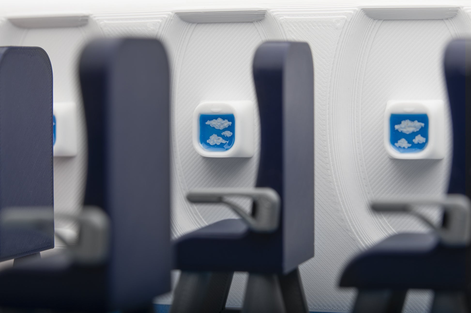 Airplane window artisan keycap, view between scale airplane seats
