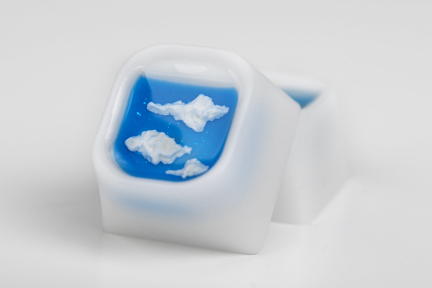 artisan keycap that looks like an airplane window with clouds in it.