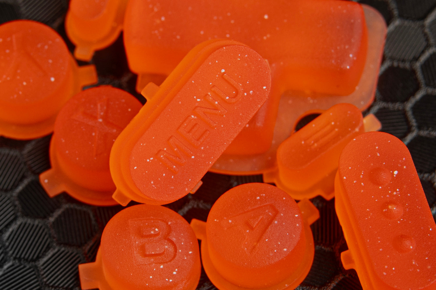 close up of menu button for steam deck in a pile of other buttons, orange sparkle