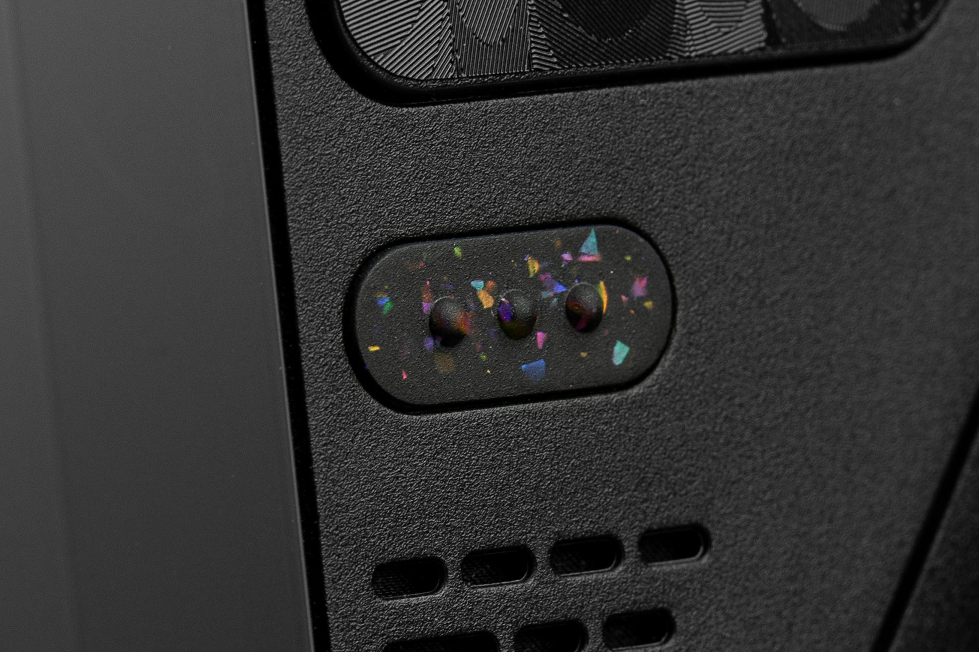 Cose up of "3 dots" button on steam deck in party black. Party black metallic shards of color mixed into black buttons.