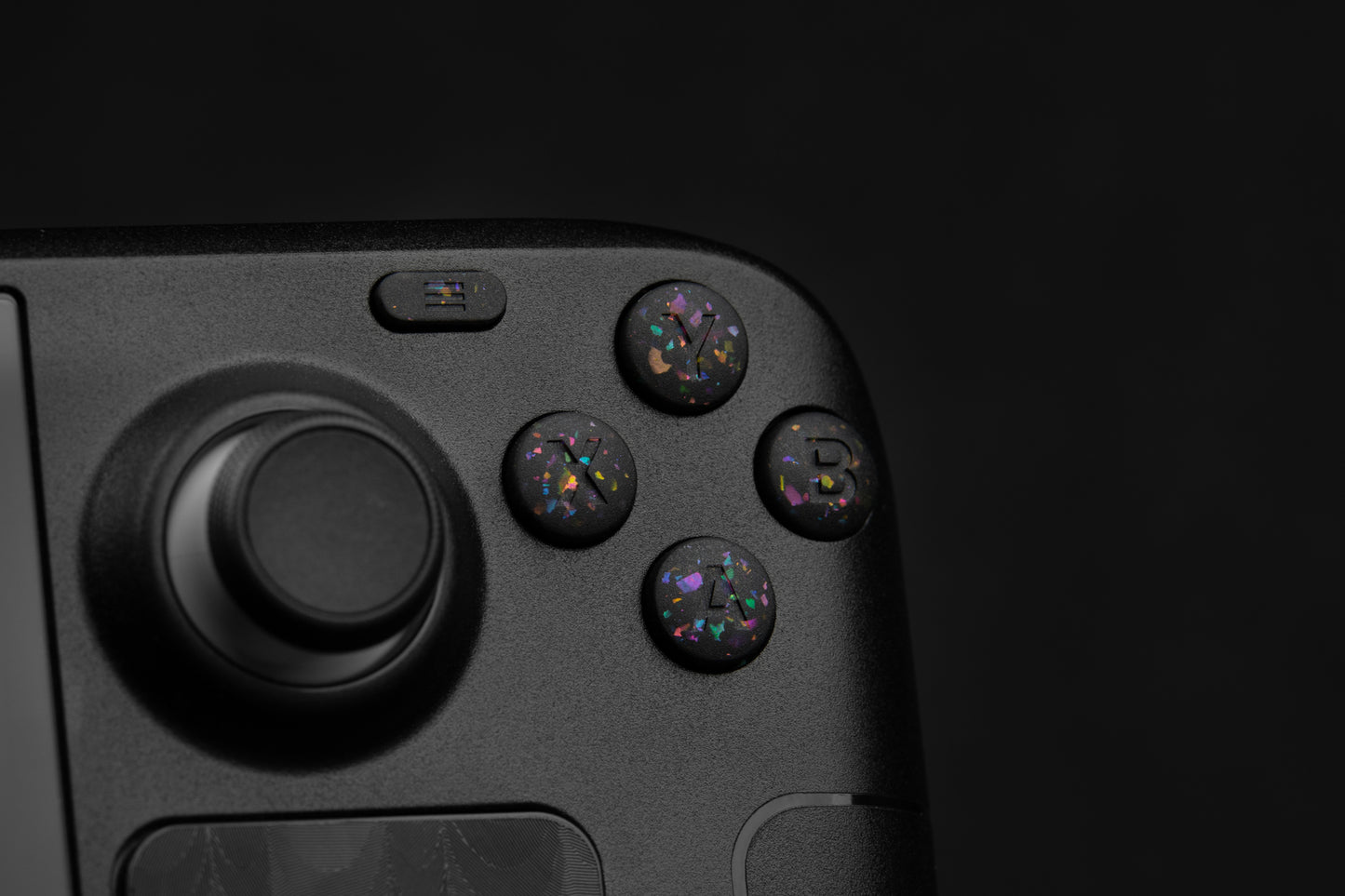 Close up abxy installed on steam deck. Party black metallic shards of color mixed into black buttons.