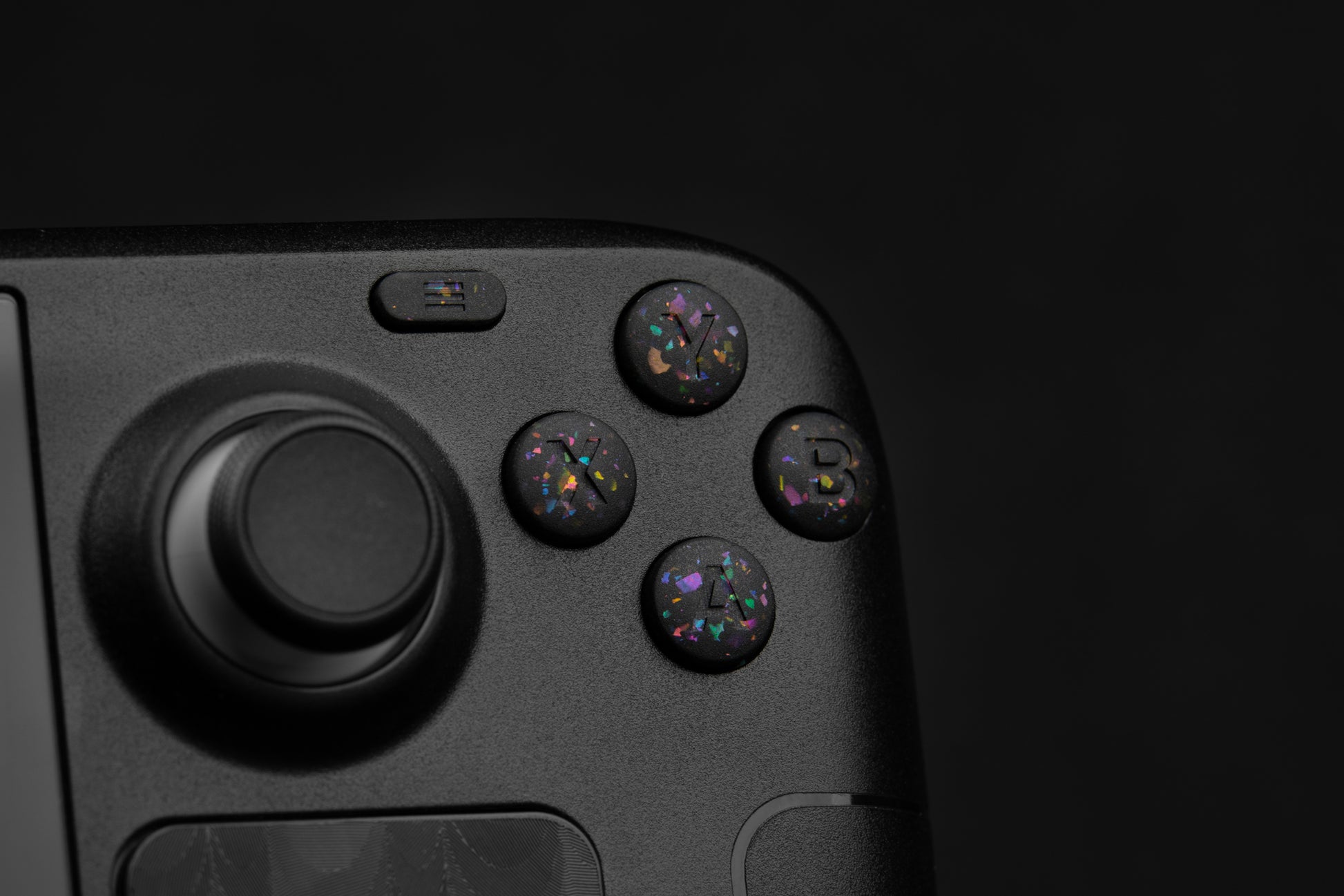 Close up abxy installed on steam deck. Party black metallic shards of color mixed into black buttons.