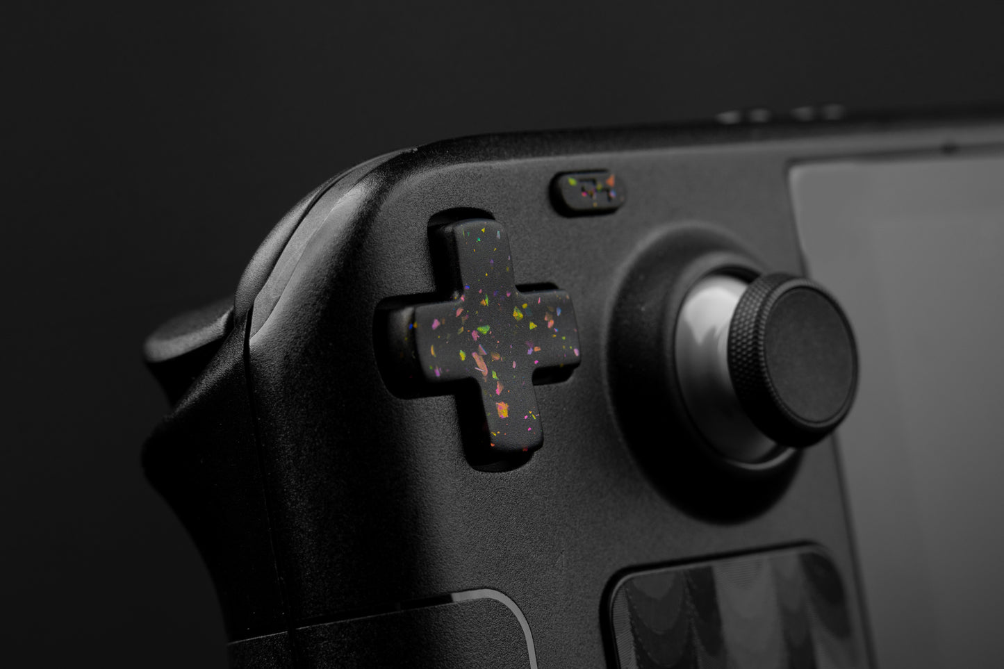 Steam deck closeup dpad with party black themed button. Party black metallic shards of color mixed into black buttons.
