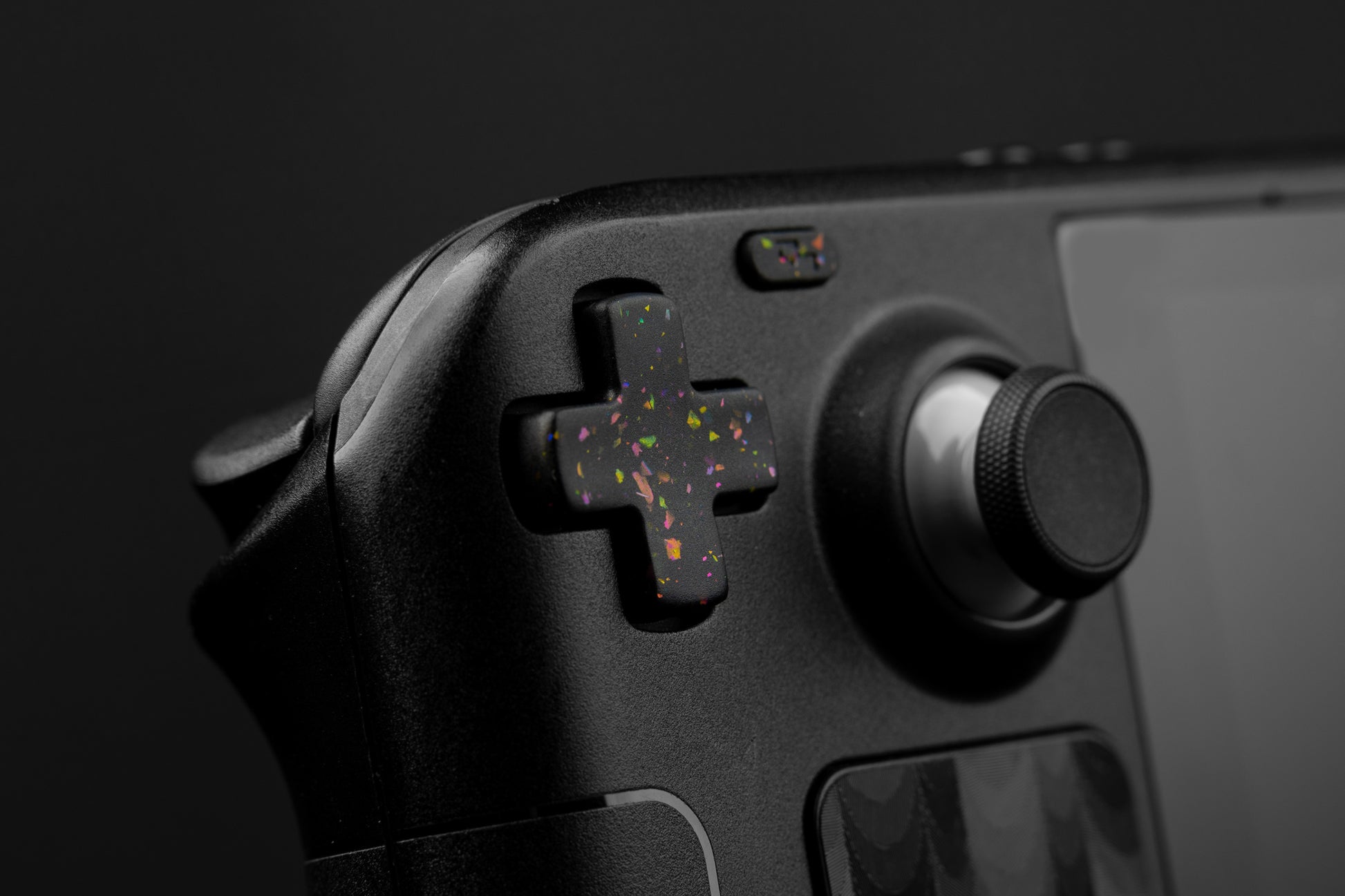 Steam deck closeup dpad with party black themed button. Party black metallic shards of color mixed into black buttons.