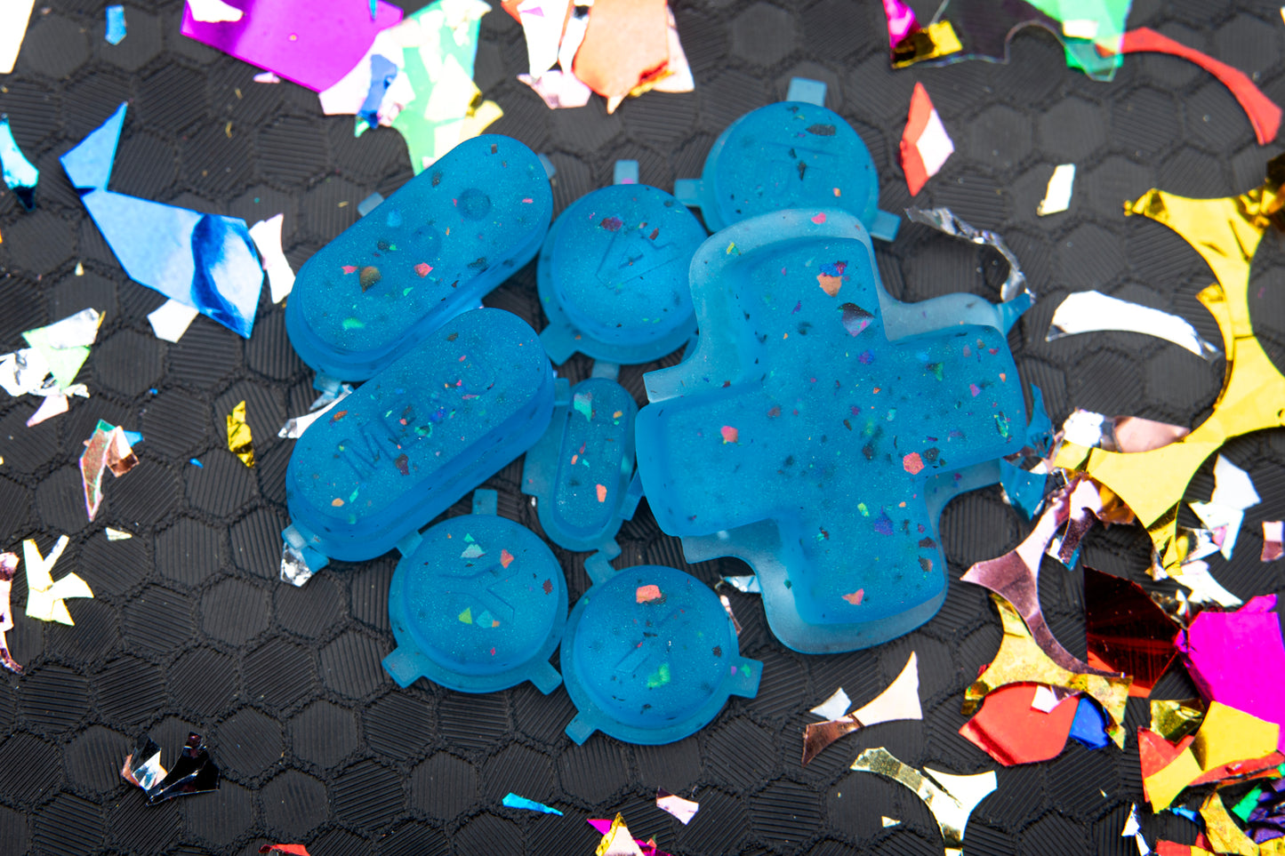 party blue close up steam deck button set in a pile. Confetti surrounding buttons on hex background.