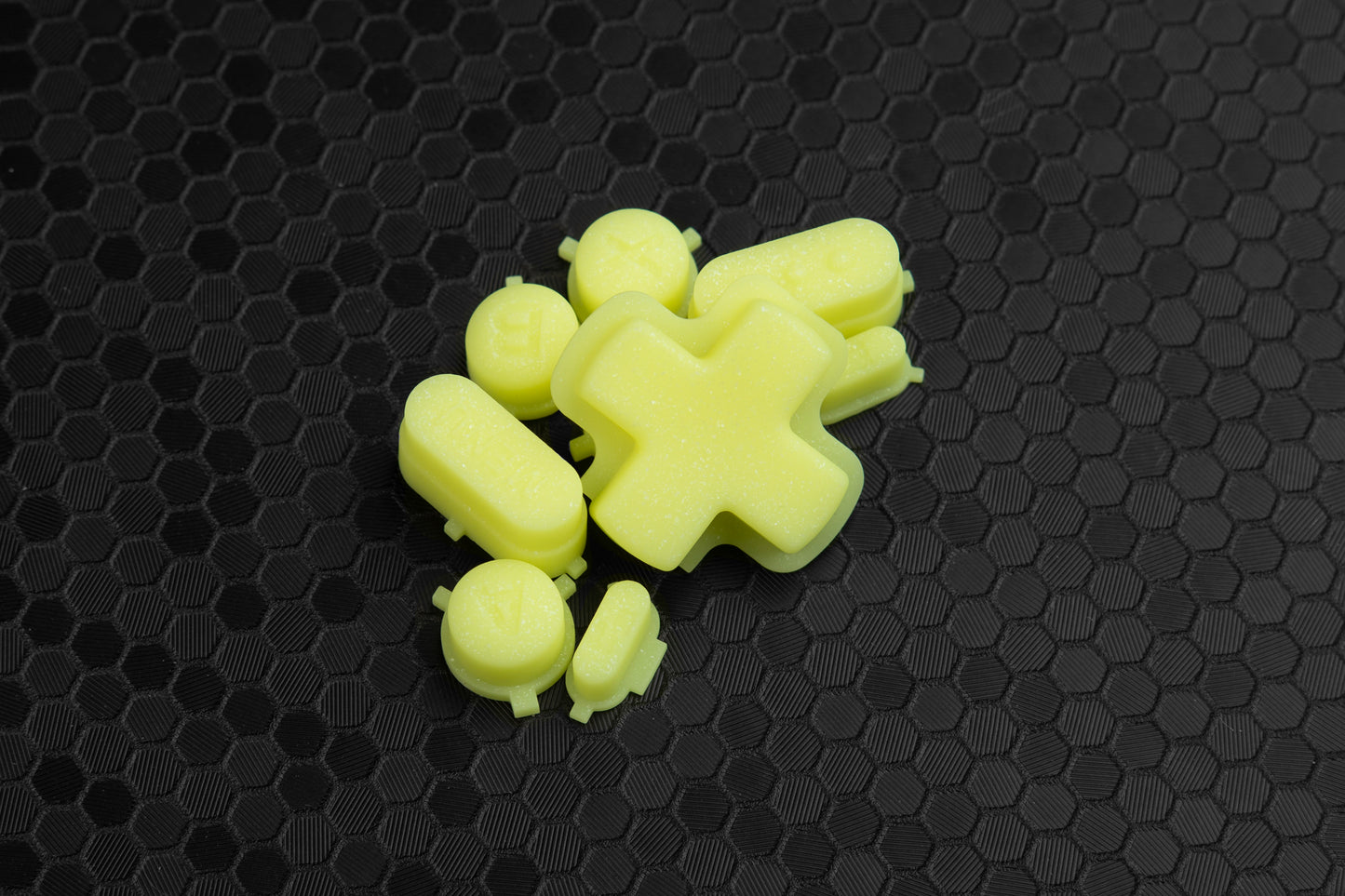 Yellow sparkly steam deck buttons in a pile on hex background