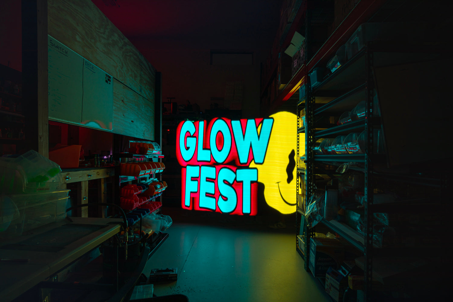 floating face logo says glow fest in warehouse environment