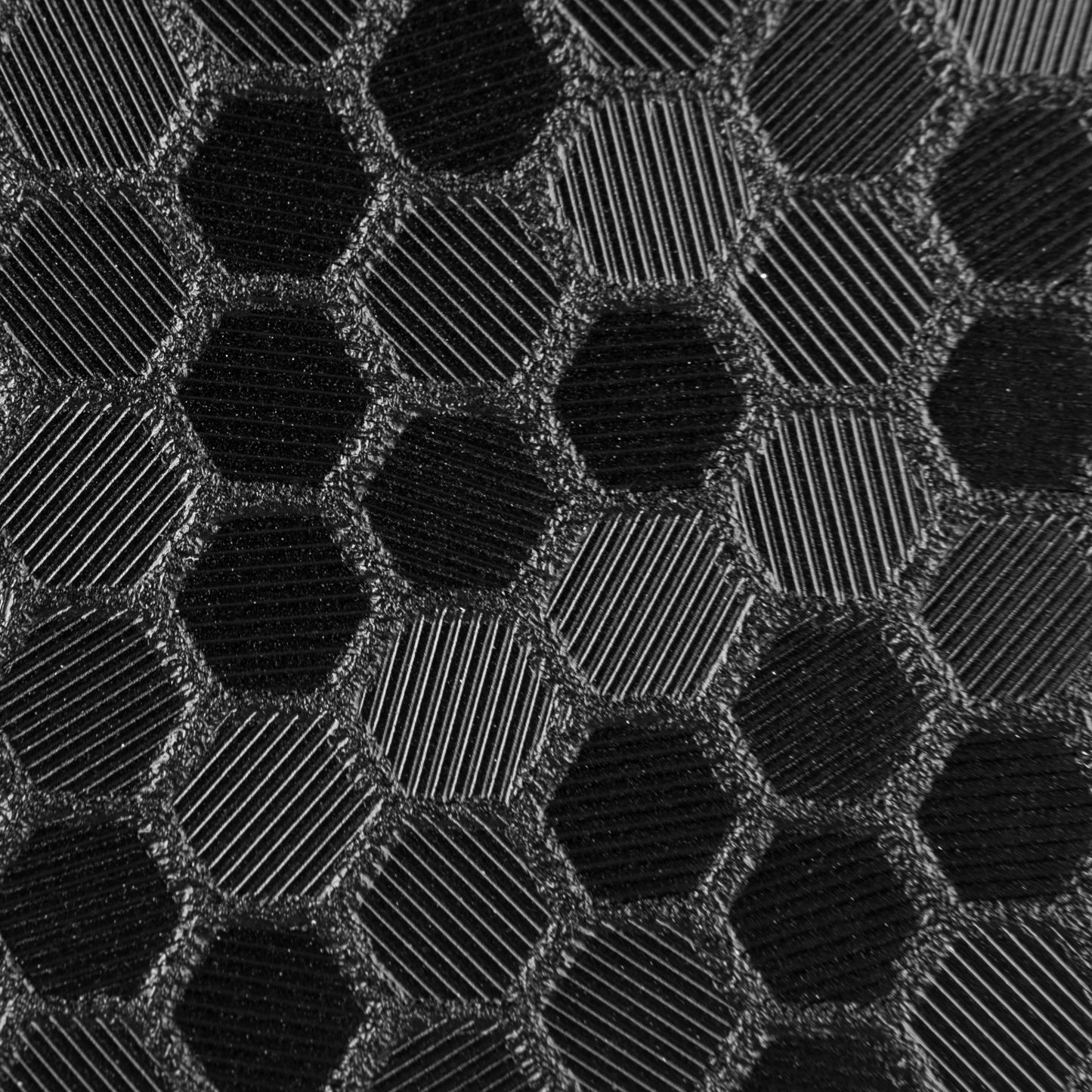 close up swatch of black hex pattern. Hexagonal shapes with cross hatching in between