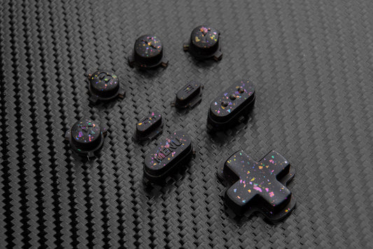 Steam deck buttons on a carbon fiber backdrop.  Black buttons with metallic shards of colors mixed throughout. 