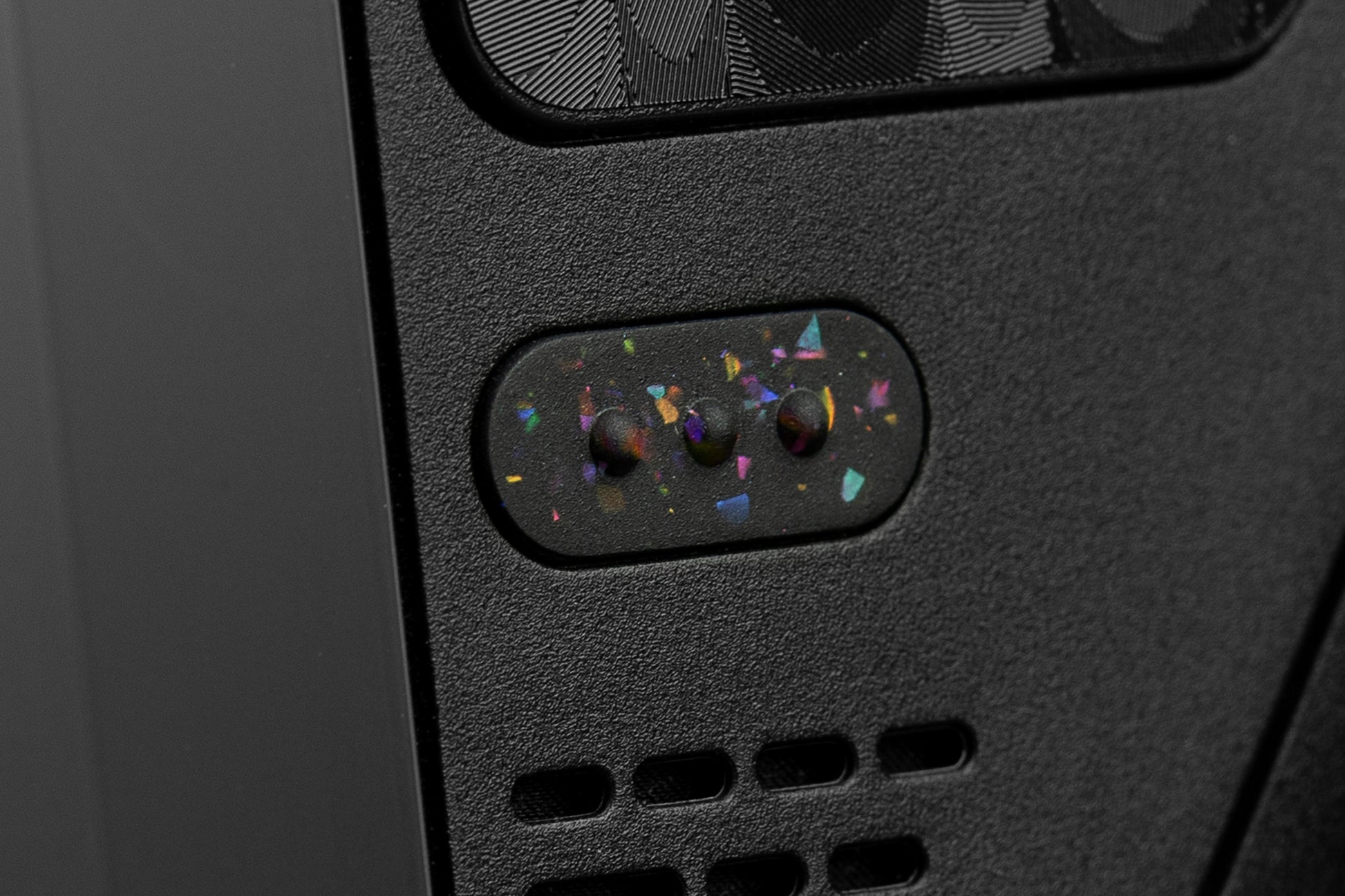 Cose up of "3 dots" button on steam deck in party black. Party black metallic shards of color mixed into black buttons. 