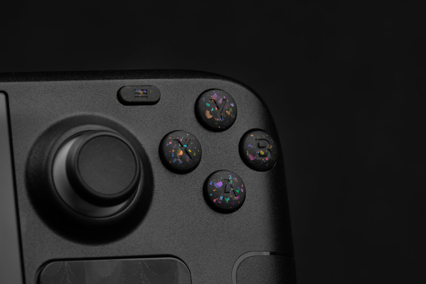 Close up abxy installed on steam deck. Party black metallic shards of color mixed into black buttons. 