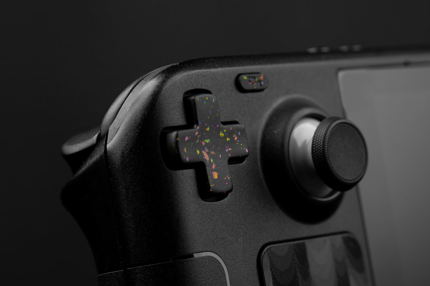 Steam deck closeup dpad with party black themed button. Party black metallic shards of color mixed into black buttons. 