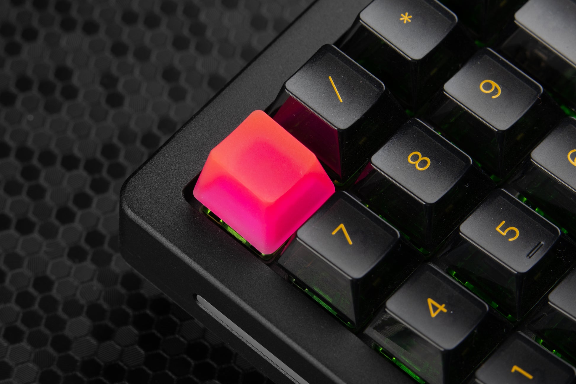 Transparent neon pink artisan keycap installed on a numpad