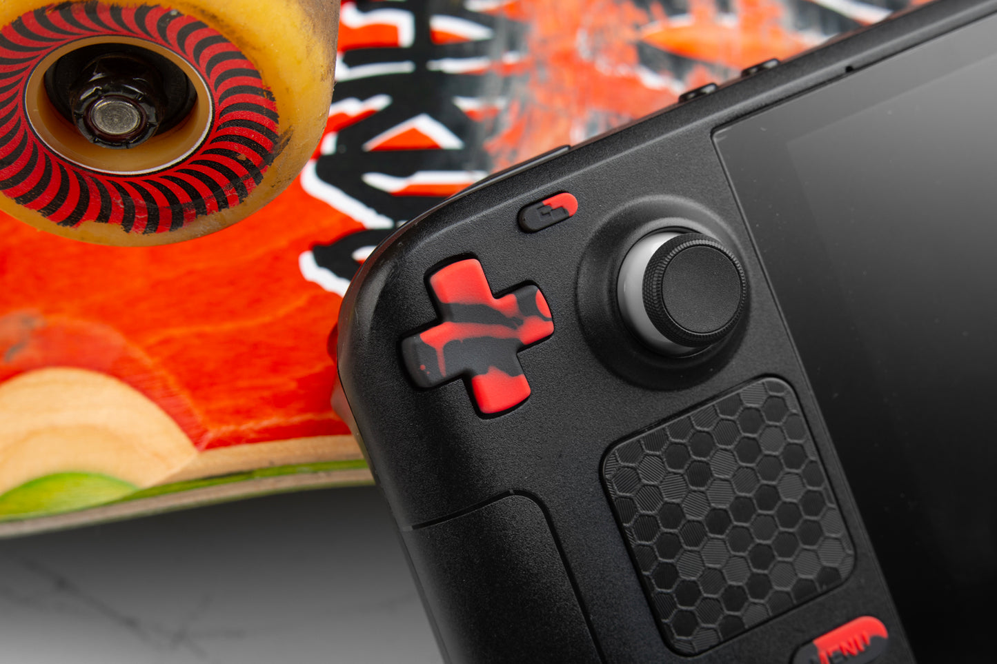 dpad with black and red blood splat theme installed in steam deck resting against a skateboard