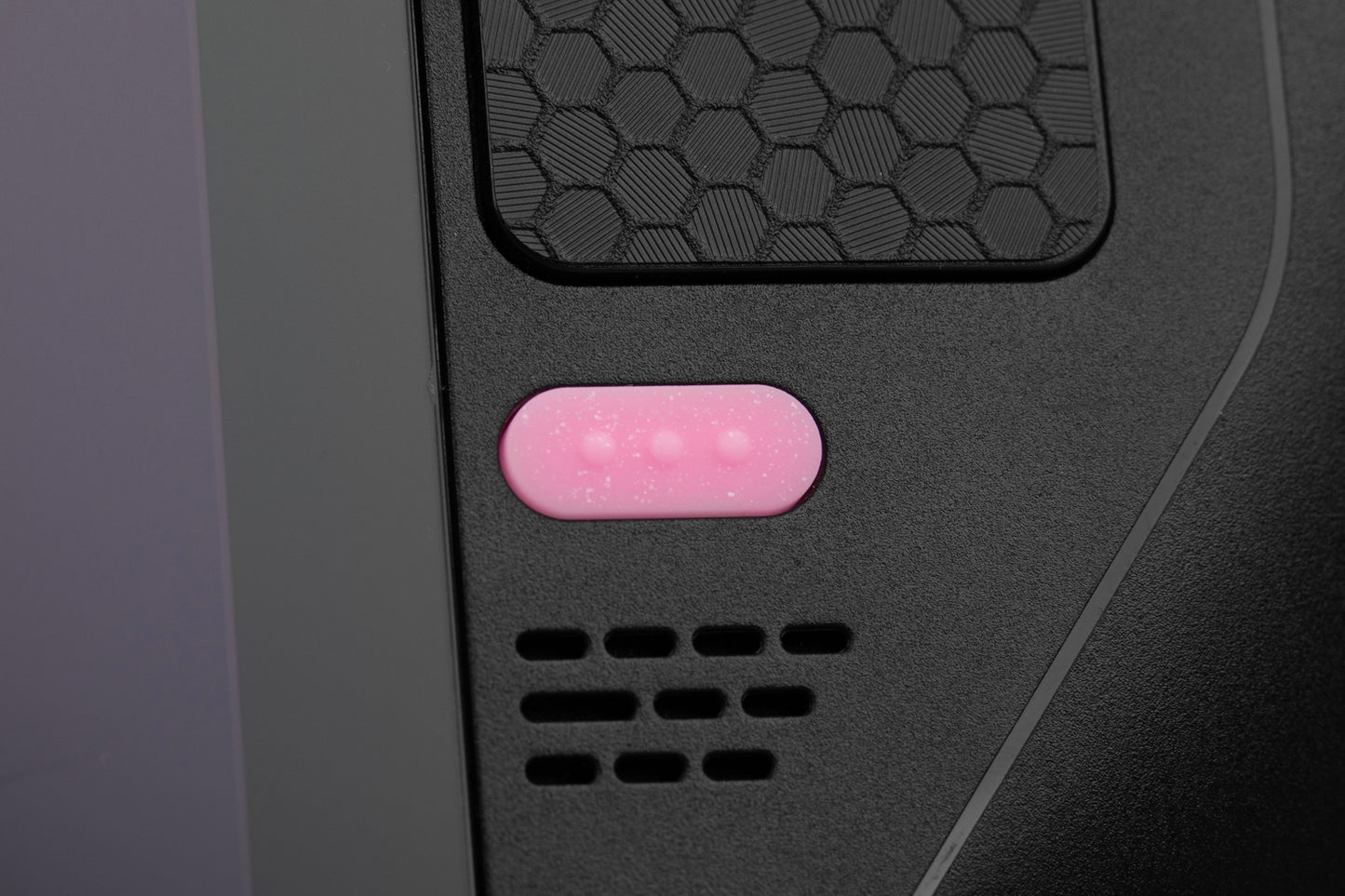 Close-up of quick access button sparkly pink installed on a black steam deck