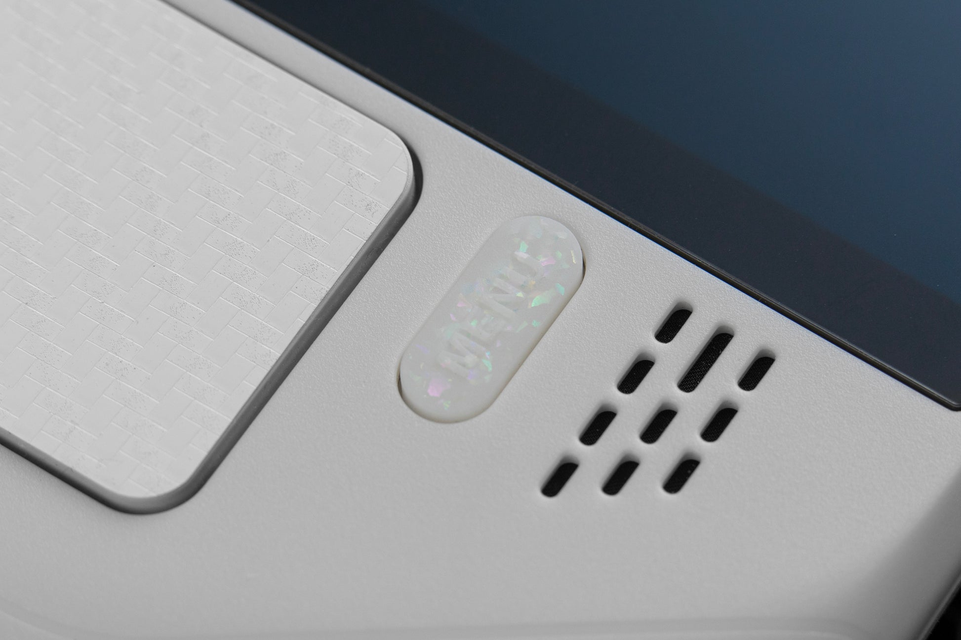 super close up of the menu button on steam deck party white holographic flake