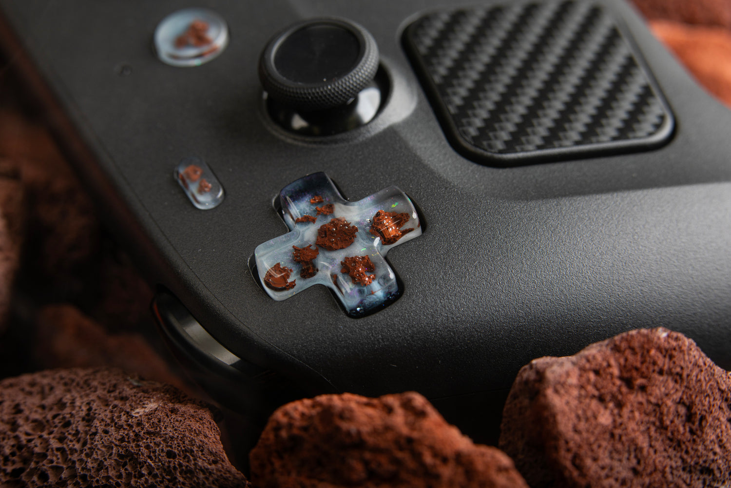 Steam Controller with asteroid buttons installed surrounded by rocks
