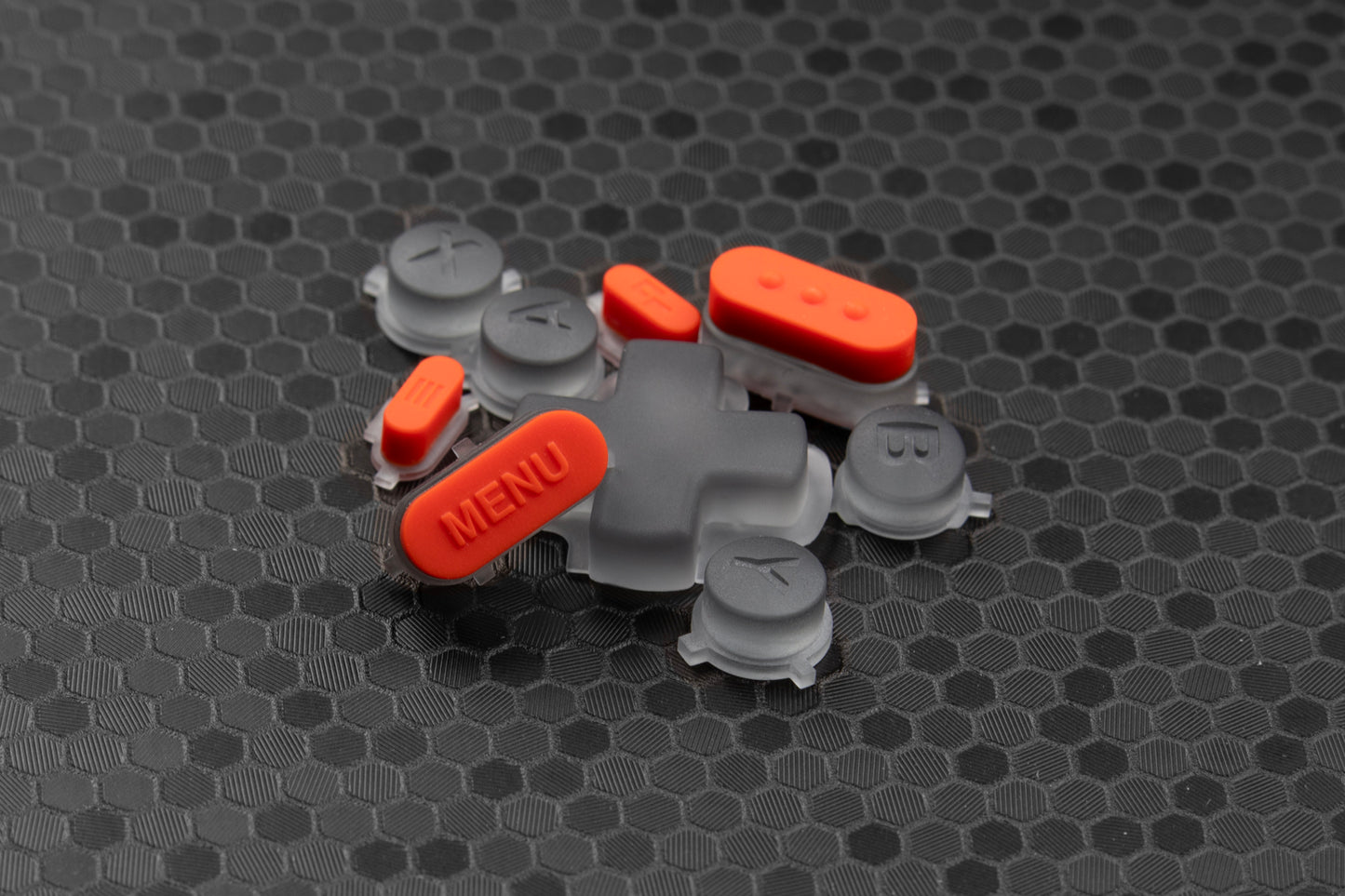 transparent grey and orange steam deck button set in a pile on a hexagonal textured background